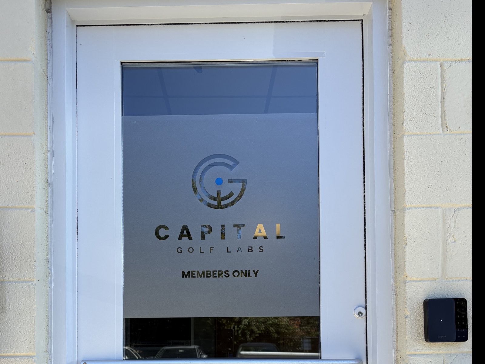 The Capital Golf Labs entrance: a glass door marked Members Only, with the door-code keypad to its right